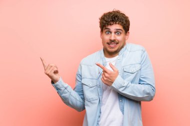 Pembe duvar üzerinde Sarışın adam korkmuş ve yan işaret