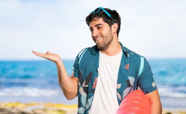 Plaja bir reklam eklemek için avuç içinde copyspace hayali tutan şort adam