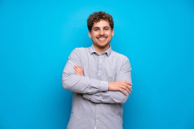 Sarışın adam mavi duvar ön konumda geçti silah tutmak