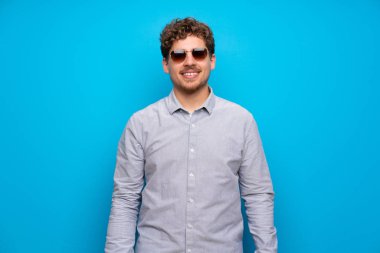 Mavi duvar gözlüklü ve mutlu sarışın adam