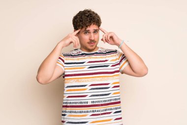 Şüpheci ve düşünme sahip izole duvar üzerinde Blonde adam