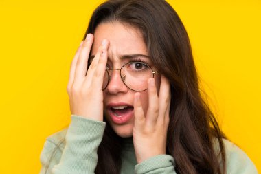 Gözleri kaplayan ve parmaklardan bakan sweatshirt ile Genç kız