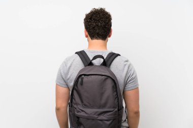 Sırt çantası ile izole duvar üzerinde kıvırcık saçlı Adam