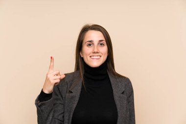 İzole edilmiş duvarın üzerinde işaret eden genç bir kadın. Harika bir fikir.