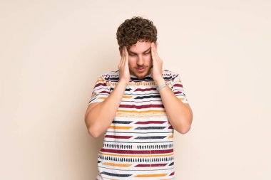 Baş ağrısı ile izole duvar üzerinde Blonde adam