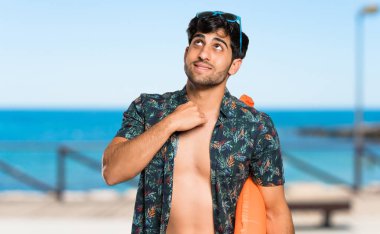 Plajda yorgun ve hasta ifade ile şort adam