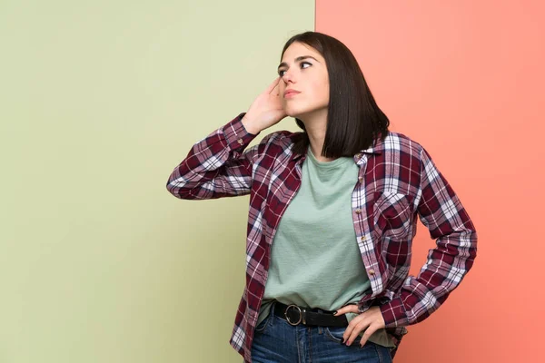 Jonge Vrouw Geïsoleerde Kleurrijke Muur Luisteren Naar Iets Door Hand — Stockfoto
