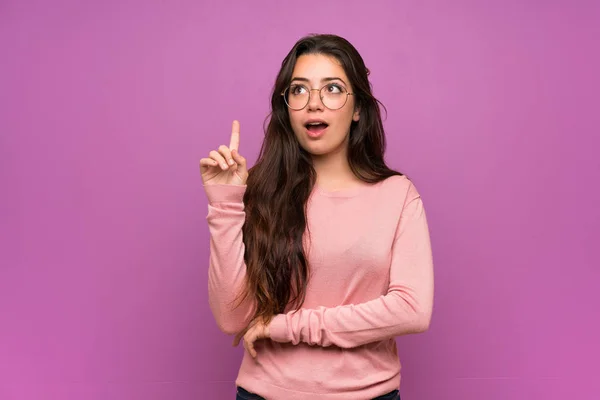 Chica Adolescente Sobre Pared Púrpura Pensando Una Idea Apuntando Con — Foto de Stock