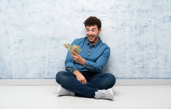 Νέος Άνθρωπος Κάθεται Στο Πάτωμα Παίρνοντας Πολλά Χρήματα — Φωτογραφία Αρχείου