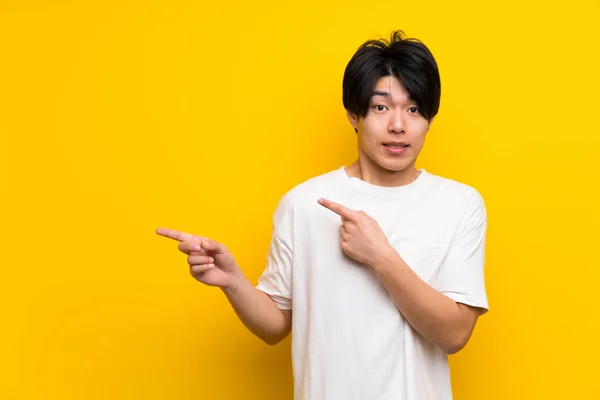 Asiatischer Mann Über Isolierte Gelbe Wand Erschrocken Und Zur Seite — Stockfoto