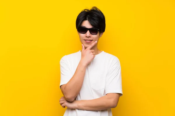 Asiático Hombre Sobre Aislado Amarillo Pared Con Gafas Sonriendo — Foto de Stock