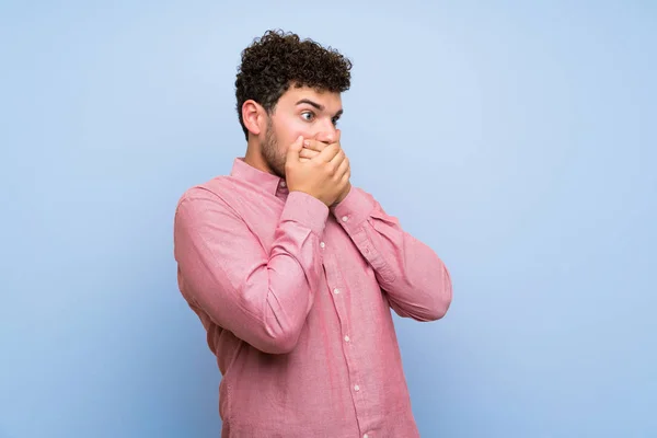 Man Curly Hair Isolated Blue Wall Covering Mouth Looking Side — Stock Photo, Image