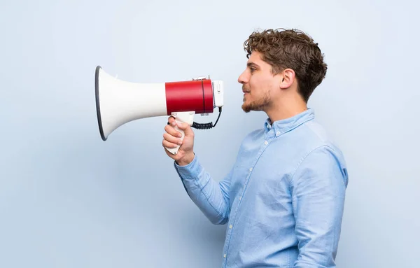 Blonde Man Blauwe Muur Schreeuwen Door Een Megafoon — Stockfoto