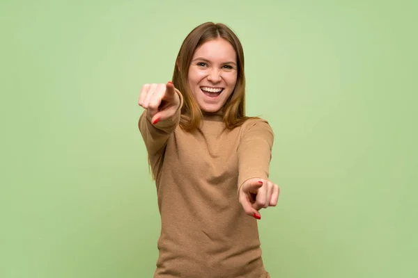 Junge Frau Mit Rollkragenpulli Zeigt Lächelnd Mit Dem Finger Auf — Stockfoto