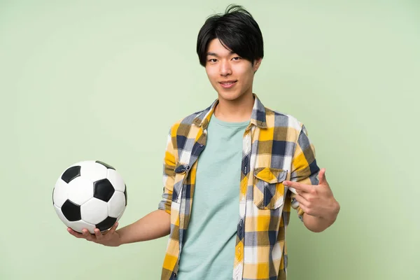 Азіатська Людина Над Ізольованою Зеленої Стіни Проведення Футбольного Яча — стокове фото