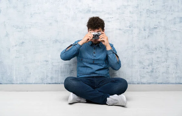 Ung Man Som Sitter Golvet Och Håller Kamera — Stockfoto