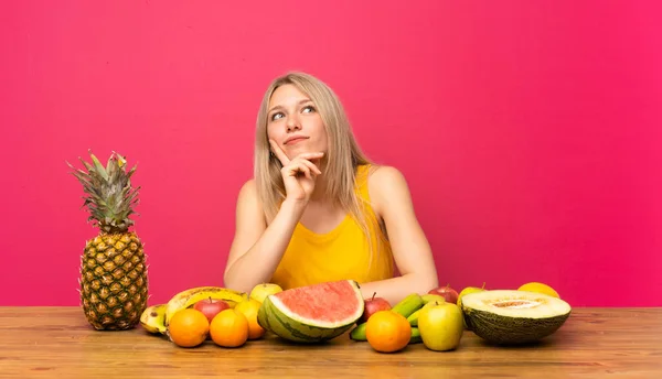 Mujer Rubia Joven Con Montón Frutas Pensando Una Idea — Foto de Stock