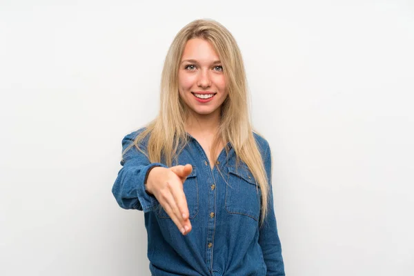 Junge Blonde Frau Über Isolierte Weiße Wand Die Hände Schüttelt — Stockfoto