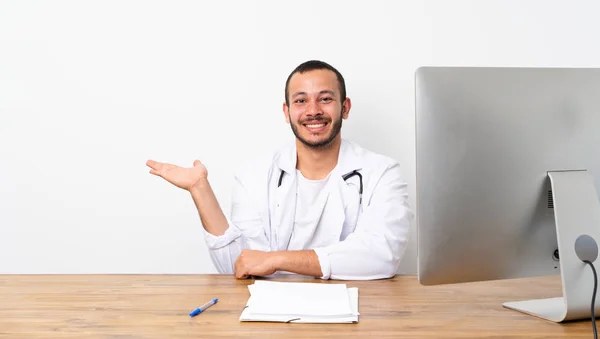 Doktor Kolumbijski Mężczyzna Trzymając Miejsce Urojoną Dłoni Aby Wstawić Reklamę — Zdjęcie stockowe