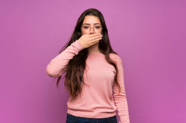 Elleri ile ağız kapsayan mor duvar üzerinde Genç kız