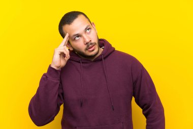 İntihar jesti yaparken sorunları ile sarı duvar üzerinde sweatshirt ile Kolombiyalı adam