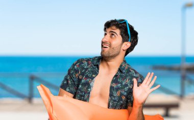 Şortlu adam plajda gülümsüyor