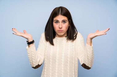 Izole mavi duvar üzerinde genç kadın yüz ifadesi karıştırmayın ile şüpheleri olan