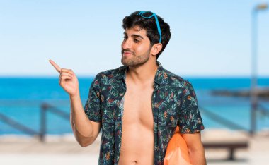 Şortlu adam sahilde yan parmak işaret