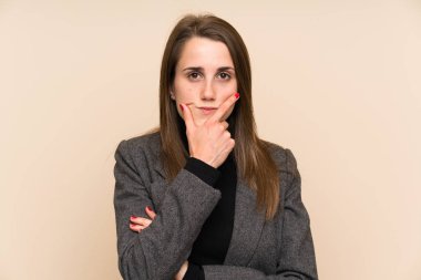 İzole edilmiş duvarın üzerinde duran ve bir fikir düşünen genç bir kadın.