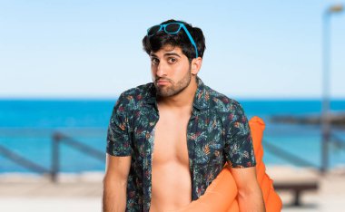 Plajda üzgün ve depresif ifade ile şort Adam