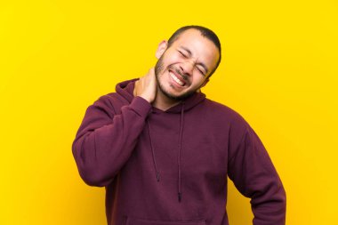 Yaka ile sarı duvar üzerinde sweatshirt ile Kolombiyalı adam