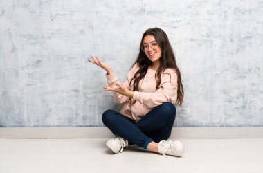 Genç öğrenci kız gelmek için davet için yan ellerini uzatan bir masada okuyan