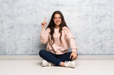 Genç öğrenci kız bir tablo gösteren ve en iyi işareti bir parmak kaldırma okuyor