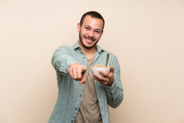 Mısır gevreği kase ile Kolombiyalı adam size parmak işaret