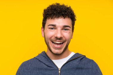 Sürpriz yüz ifadesi ile izole sarı duvar üzerinde genç adam