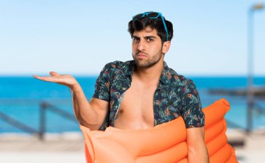 Şortlu adam sahilde bir şey anlamadığı için mutsuz