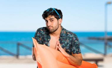 Sandıklı adam avuç içini bir arada tutar. Kişi plajda bir şey ister