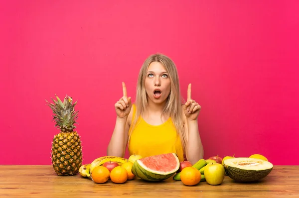 Mujer Rubia Joven Con Montón Frutas Señalando Con Dedo Índice — Foto de Stock