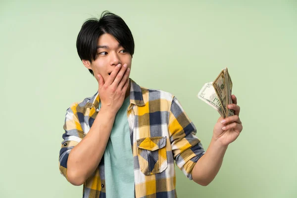 Азіатська Людина Над Ізольованою Зеленої Стіни Приймаючи Багато Грошей — стокове фото
