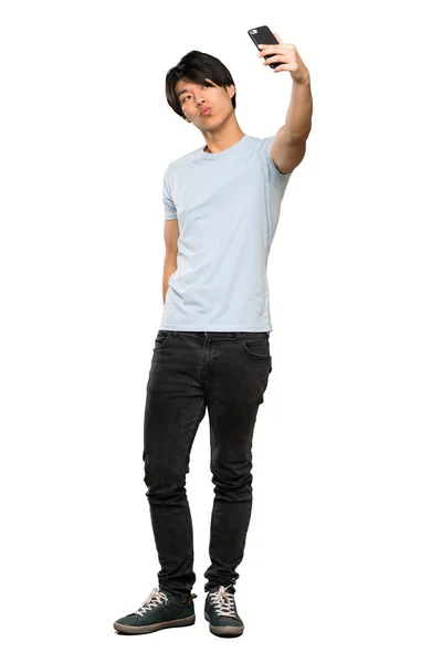 青いシャツを着たアジア人男性が孤立した白い背景の上に自分撮りをするフルレングスのショット — ストック写真