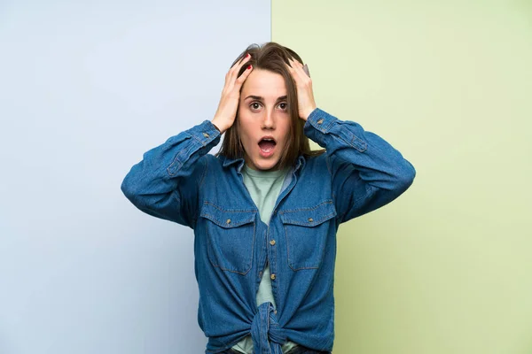 Young woman over colorful background with surprise facial expression