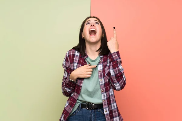 Genç Bir Kadın Izole Olmuş Renkli Bir Duvarı Işaret Ediyor — Stok fotoğraf