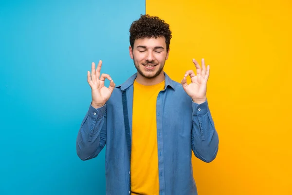 Homem Com Cabelo Encaracolado Sobre Parede Colorida Pose Zen — Fotografia de Stock