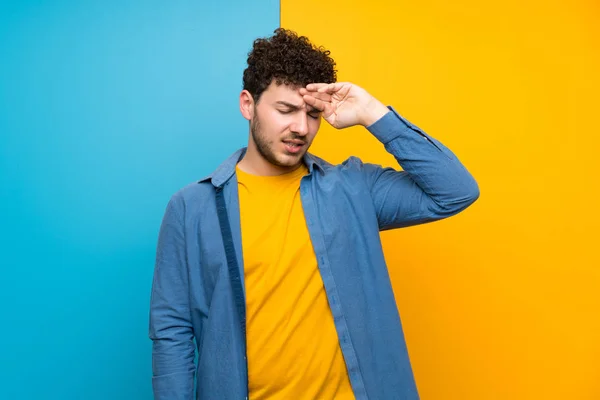 Homem Com Cabelo Encaracolado Sobre Parede Colorida Com Expressão Cansada — Fotografia de Stock