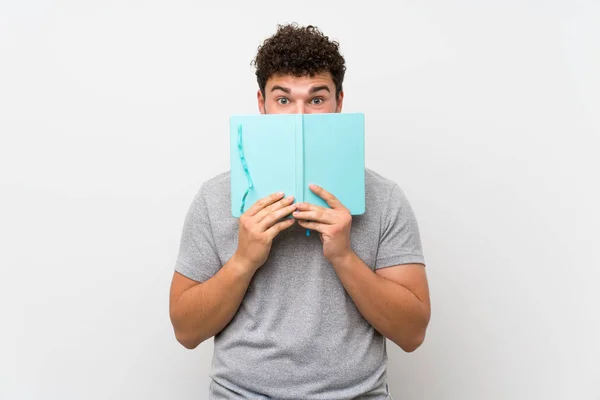 Hombre Con Pelo Rizado Sobre Pared Aislada Sosteniendo Leyendo Libro — Foto de Stock