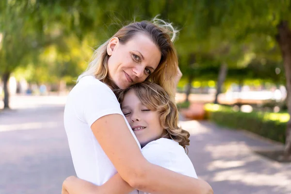 Mother and son in a park hugging and hugging