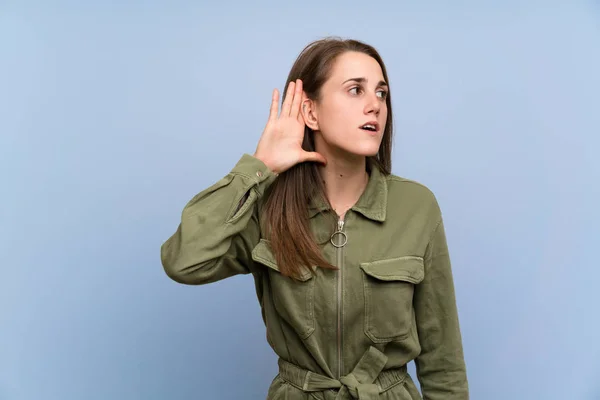 Young Woman Isolated Blue Wall Listening Something — Zdjęcie stockowe