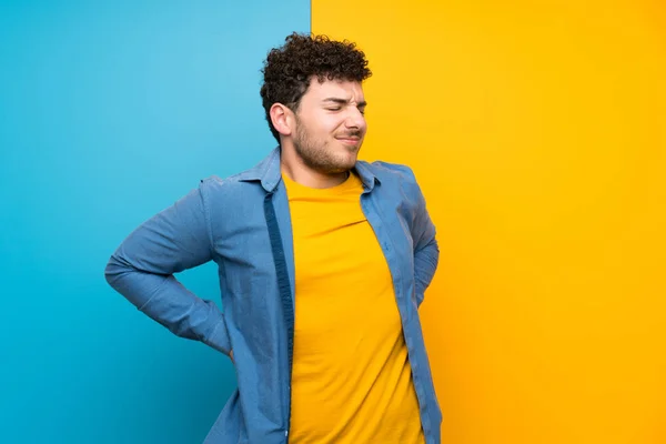 Homem Com Cabelo Encaracolado Sobre Parede Colorida Sofrendo Dor Nas — Fotografia de Stock