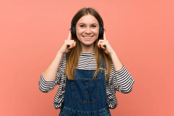 Young Woman Overalls Pink Wall Listening Music Headphones — 스톡 사진