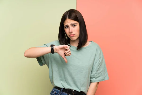 Młoda Kobieta Nad Odizolowanym Kolorowe Ściany Pokazując Kciuk Dół Znak — Zdjęcie stockowe